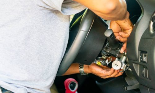 close up hand of technician during repair key or switch engine start of sedan car